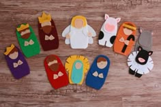 several felt puppets are arranged on a wooden surface, including one with an angel and the other with a lion