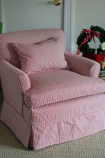 a red and white striped chair sitting next to a christmas tree