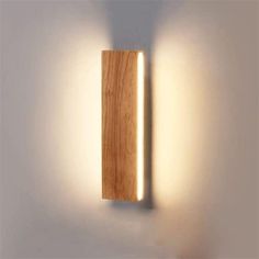 a wooden light fixture mounted to the side of a wall