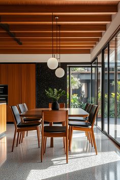 a dining room table with chairs and a potted plant