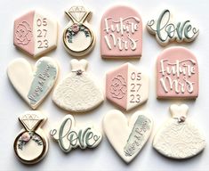 some decorated cookies are arranged in the shape of wedding rings and engagement rings with names on them