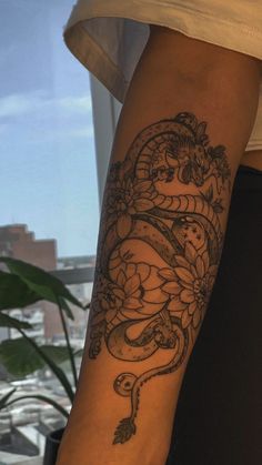 a woman's arm with a tattoo on it and a snake in the middle