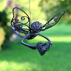 a metal wire sculpture hanging from a string