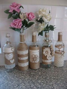 several bottles with flowers in them sitting on a counter