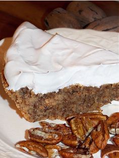 there is a piece of cake on the plate with pecans and whipped cream around it