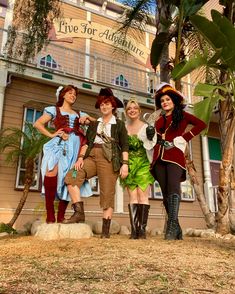 four women dressed up in costumes posing for a photo outside the five foot adventure building