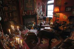 a living room filled with lots of furniture next to a fire place covered in candles