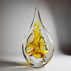 a glass vase filled with yellow liquid on top of a white table