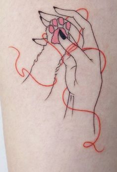 a woman's arm with a tattoo on it that has red lines in the shape of hands