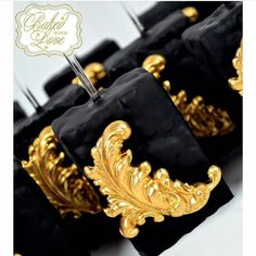 black and gold cake with golden decorations on top