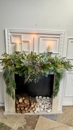 a fireplace decorated with greenery and candles