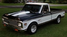 a black and white truck parked in the grass