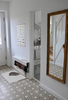 a room with a mirror, stove and rug on the floor in front of it