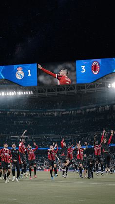 a group of men standing on top of a soccer field next to each other in front of a crowd