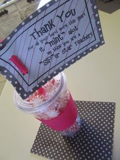 a thank you card in a cup on a table with polka dots and pink sprinkles