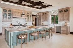 a large kitchen with an island in the middle and lots of counter space on one side