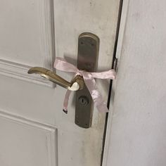 a door handle with a pink ribbon tied around it