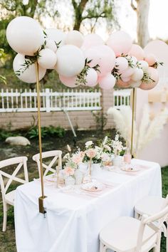 a table with balloons and flowers on it