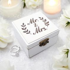 a wedding ring box with the word mr and mrs written on it next to flowers