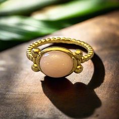 Le nom en dit long. Cette bague majestueuse est délicate et élégante, son design classiquement éternel, avec une tige délicatement cannelée qui orne magnifiquement la pierre cabochon centrale comme si c'était une couronne. Le sertissage de la pierre est encadré par quatre boules ornementales. Cette incroyable bague est parfaite pour chaque occasion et est basée sur un exemple romain exquis et unique du deuxième siècle après J.-C.
"Maiestas" signifie "majesté." Luxury Oval Gemstone Stackable Rings, Elegant Gold Moonstone Ring In Brass, Elegant Moonstone Ring With Bezel Setting, Elegant 14k Gold Cabochon Moonstone Ring, Elegant Gold Moonstone Ring With Round Band, Gold Jewelry With Fluted Bezel For Gift, Elegant Opal Ring With Bezel Setting, Gold Spiritual Rings With Bezel Setting, Elegant Yellow Gold Moonstone Ring With Center Stone