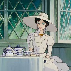 a woman sitting at a table in front of a teapot and coffee pot, with a window behind her