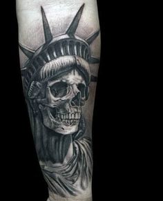 a man's leg with a statue of liberty tattoo on it and a skull in the middle