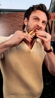 a man eating a sandwich in front of a building