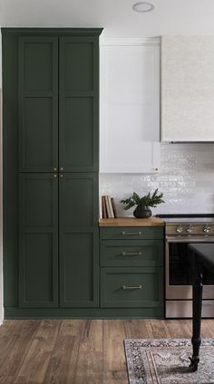 a kitchen with green cabinets and white walls