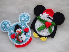 two crocheted mickey mouse and snowman coasters sitting on a table top