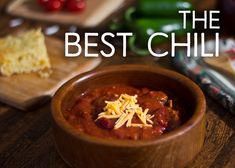 a wooden bowl filled with chili sauce next to other food on cutting boards and spoons