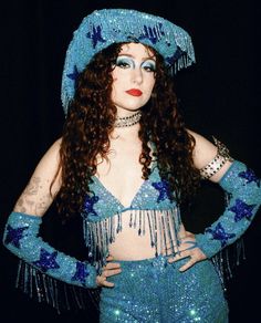 a woman with long hair wearing a blue costume