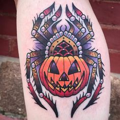 a tattoo design on the leg of a person with an orange pumpkin and feathers in it