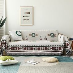 a living room with a couch, rug and potted plant on the side table