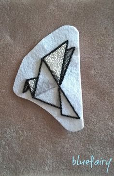 an origami bird made out of white fabric on a brown carpeted surface