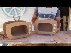 two cardboard tvs sitting on top of a wooden table