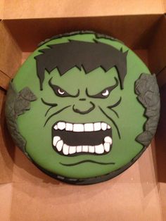 a green cake with an image of the hulk face on it's front and side