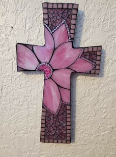 a stained glass cross with pink flowers on it