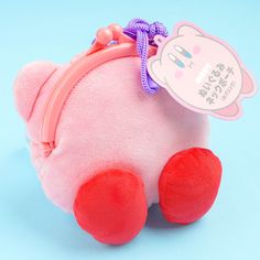 a pink and red stuffed animal sitting on top of a blue surface