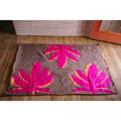 a pink and brown rug with leaves on it