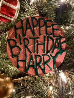 a happy birthday ornament hanging from a christmas tree