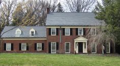 a large brick house with black shutters and windows