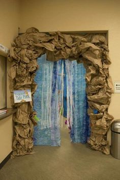 an open door with some paper on the outside and blue curtains hanging from it's sides