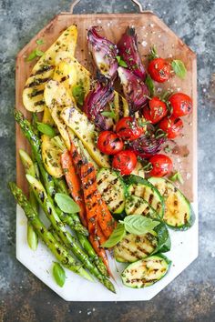 grilled vegetables are arranged on a cutting board