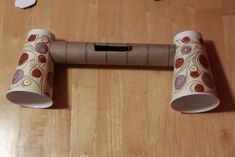 two toilet paper rolls sitting on top of a wooden floor next to a roll of toilet paper