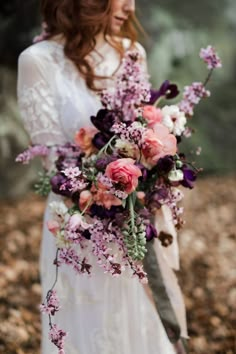 a woman in a white dress holding a bouquet of pink and purple flowers on her wedding day