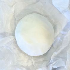 an uncooked ball of dough sitting on top of some white waxed paper