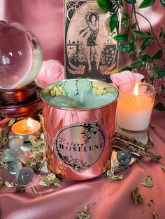 two candles sitting on top of a pink table cloth