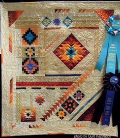 a quilted wall hanging with a blue ribbon on it and an award for the best quilt