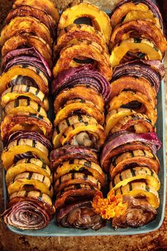 an assortment of different types of food on a platter with oranges and onions