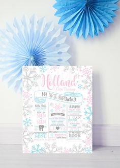 a baby's first birthday calendar with snowflakes and paper fans in the background